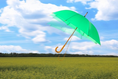 Image of Open umbrella blown by wind gust outdoors