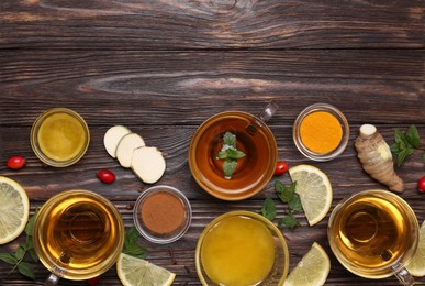 Photo of Flat lay composition of tea with honey and ingredients on wooden table. Space for text
