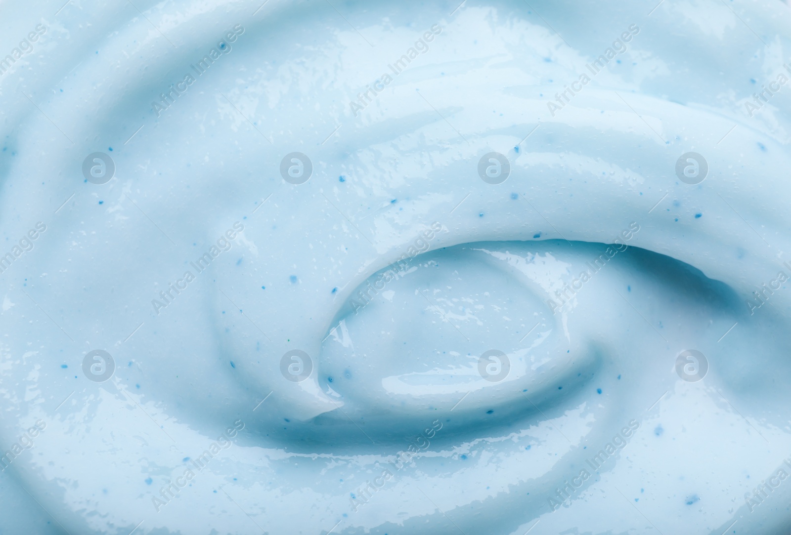 Photo of Closeup view of light blue body cream as background