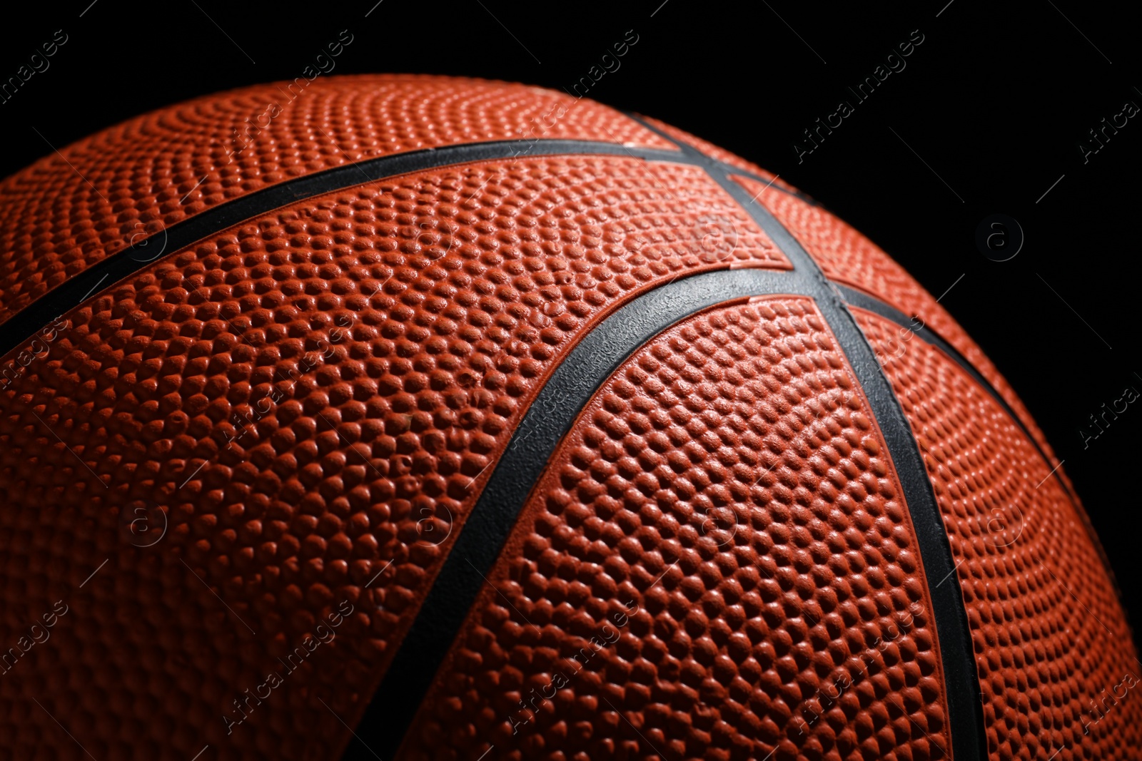 Photo of Orange basketball ball on black background, closeup