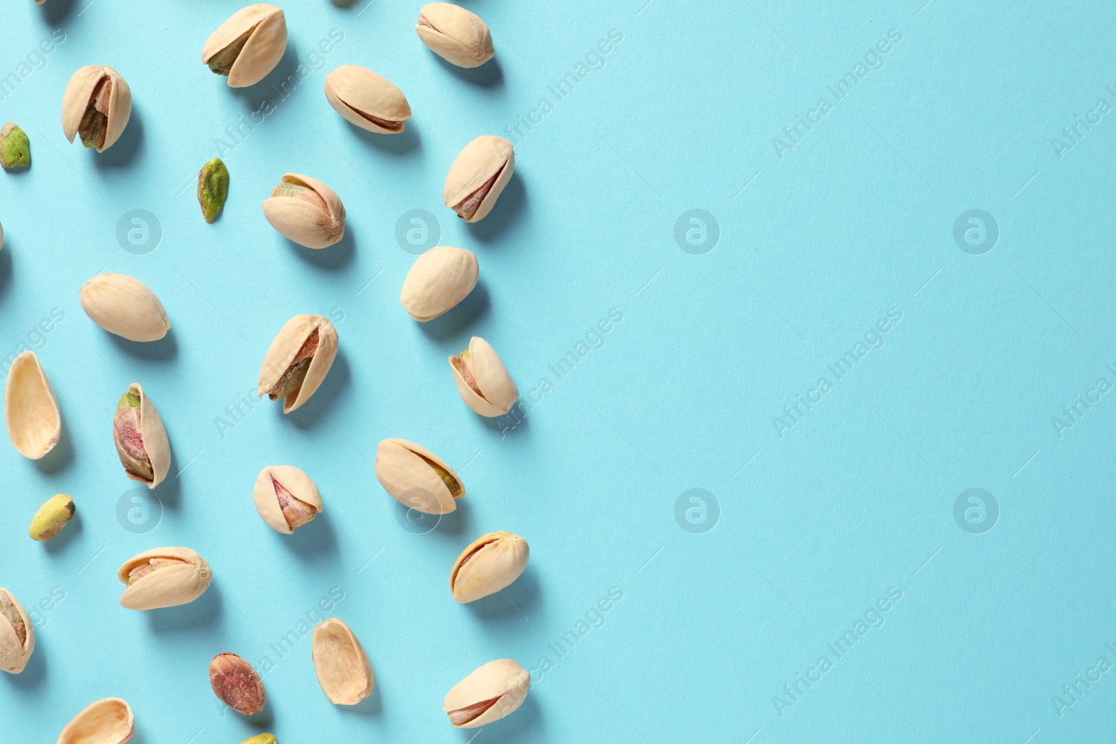 Photo of Composition with organic pistachio nuts on color background, flat lay. Space for text