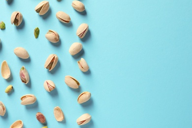 Photo of Composition with organic pistachio nuts on color background, flat lay. Space for text