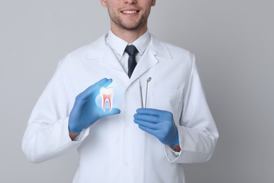Image of Dentist showing virtual model of tooth on light grey background, closeup