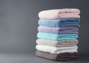 Photo of Different fresh soft terry towels on grey background