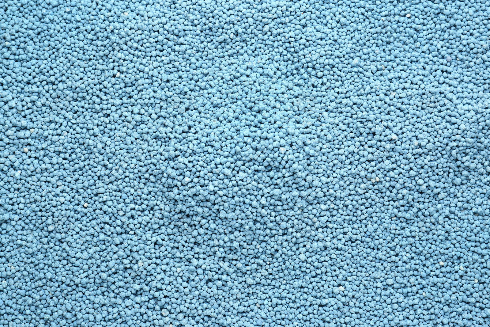 Photo of Blue granular mineral fertilizer as background, top view