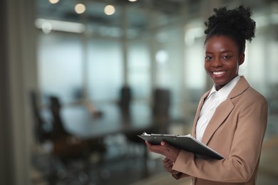 Image of Lawyer, consultant, business owner. Confident woman with clipboard smiling indoors, space for text