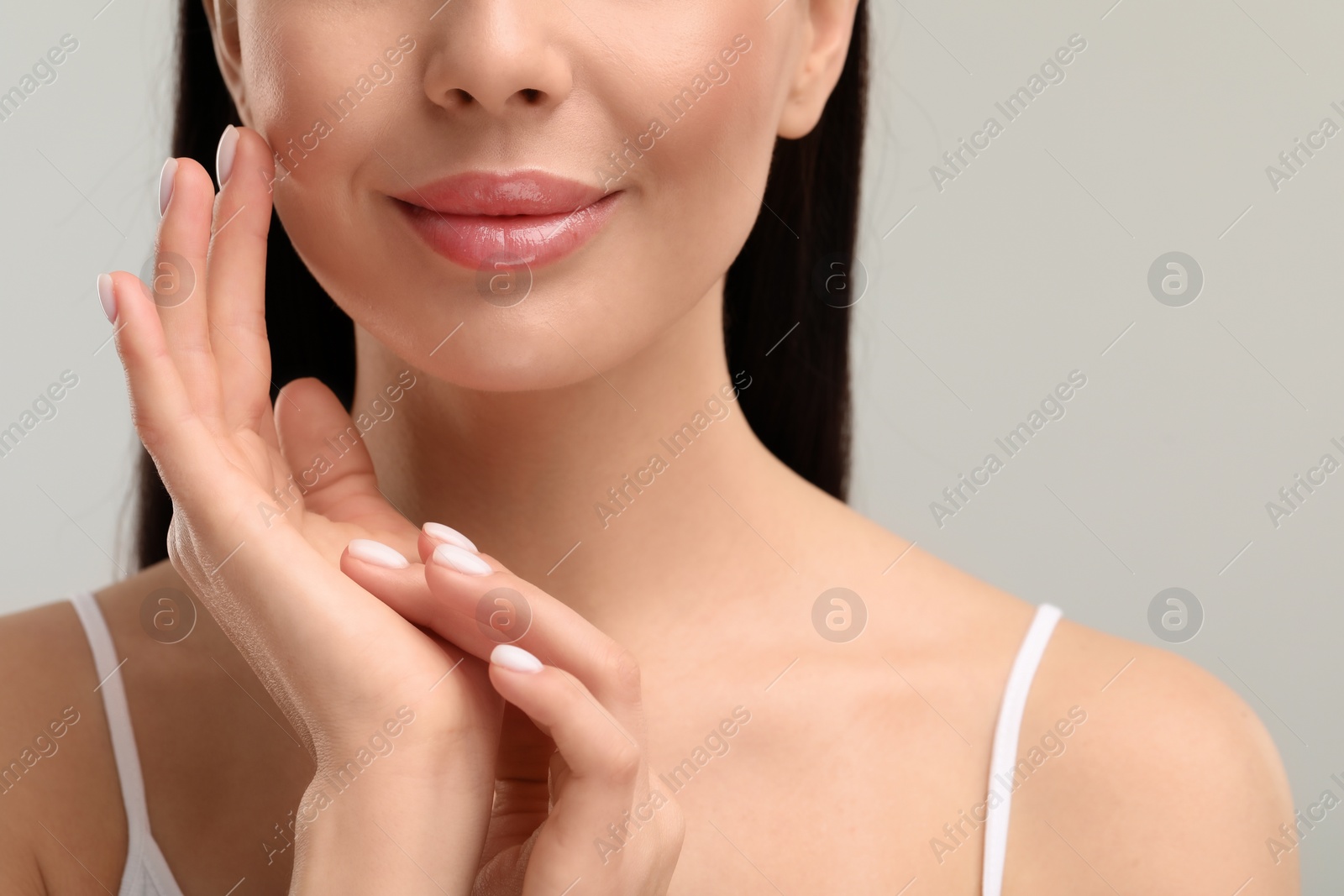 Photo of Beautiful woman with healthy skin on gray background, closeup