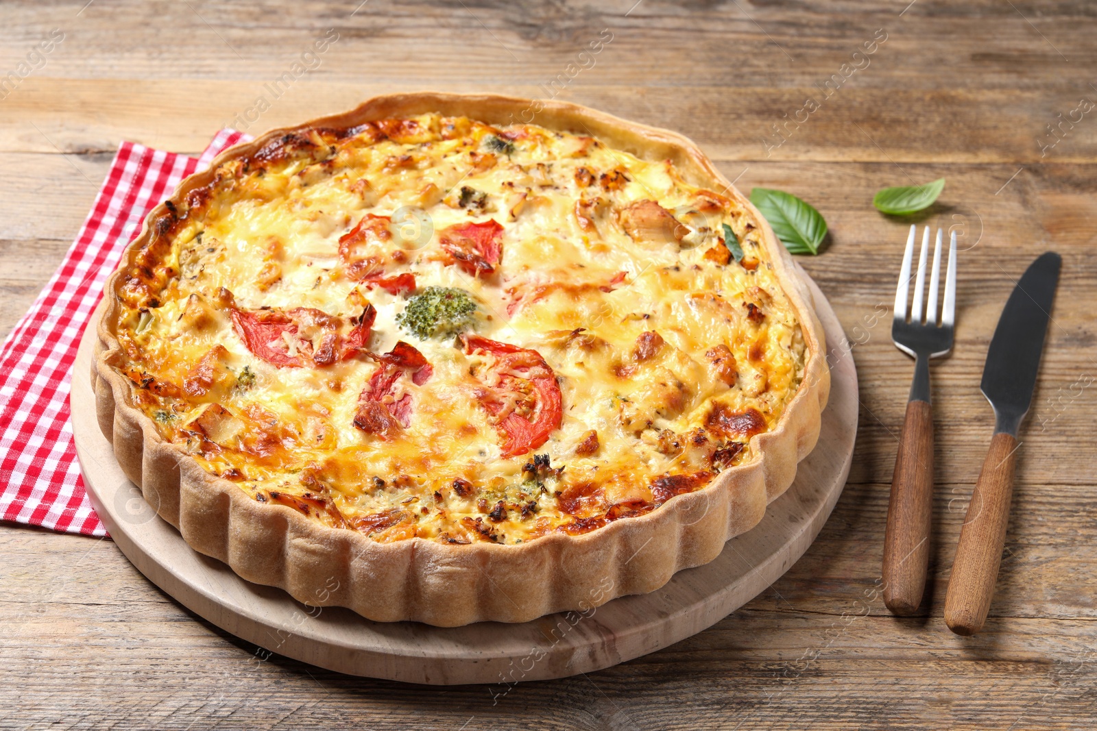 Tasty quiche with tomatoes and cheese served on wooden table, closeup Photo of Tasty quiche with tomatoes and cheese served on wooden table, closeup