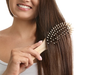 Woman with hair brush on white background, closeup