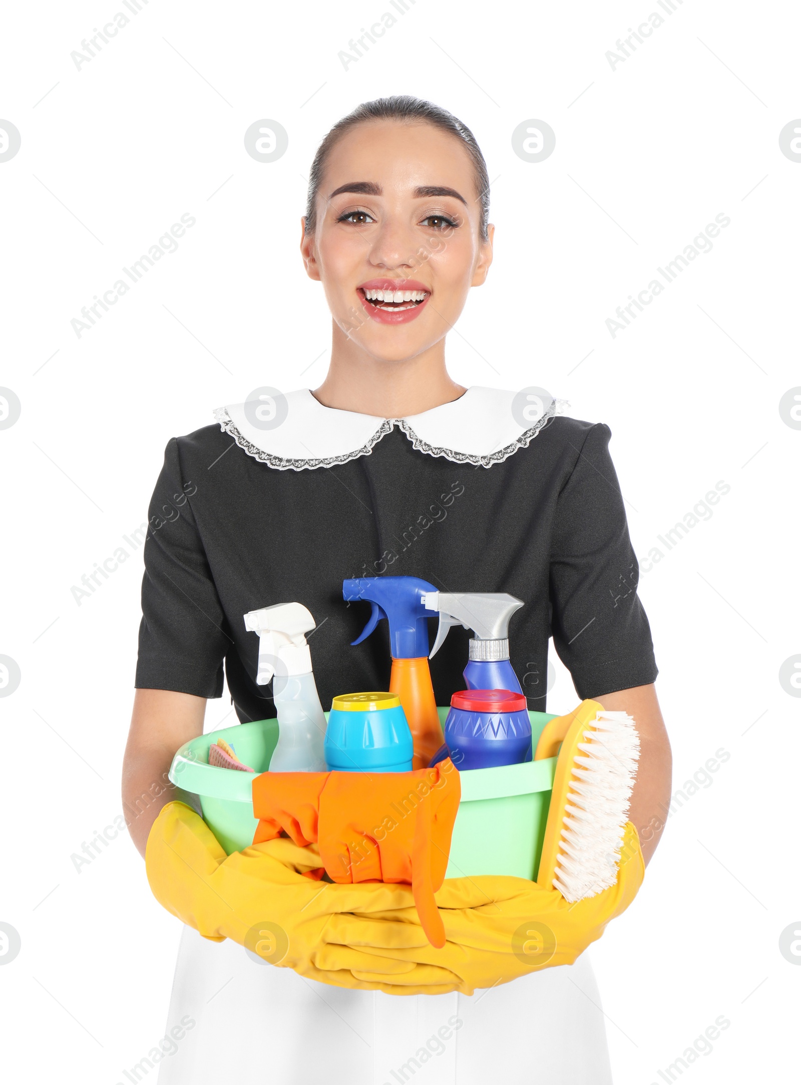 Photo of Young chambermaid holding plastic basin with detergents on white background