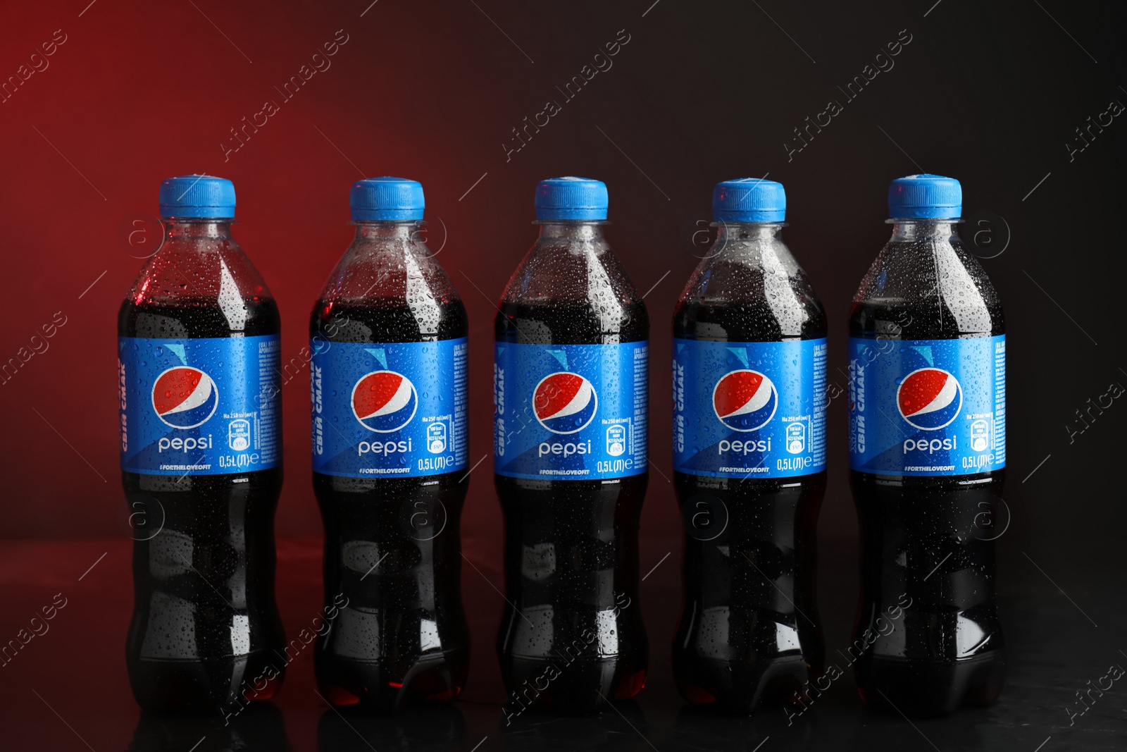 Photo of MYKOLAIV, UKRAINE - FEBRUARY 08, 2021: Plastic bottles of Pepsi with water drops on color background