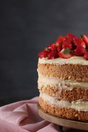 Tasty cake with fresh strawberries and mint on table against dark gray background