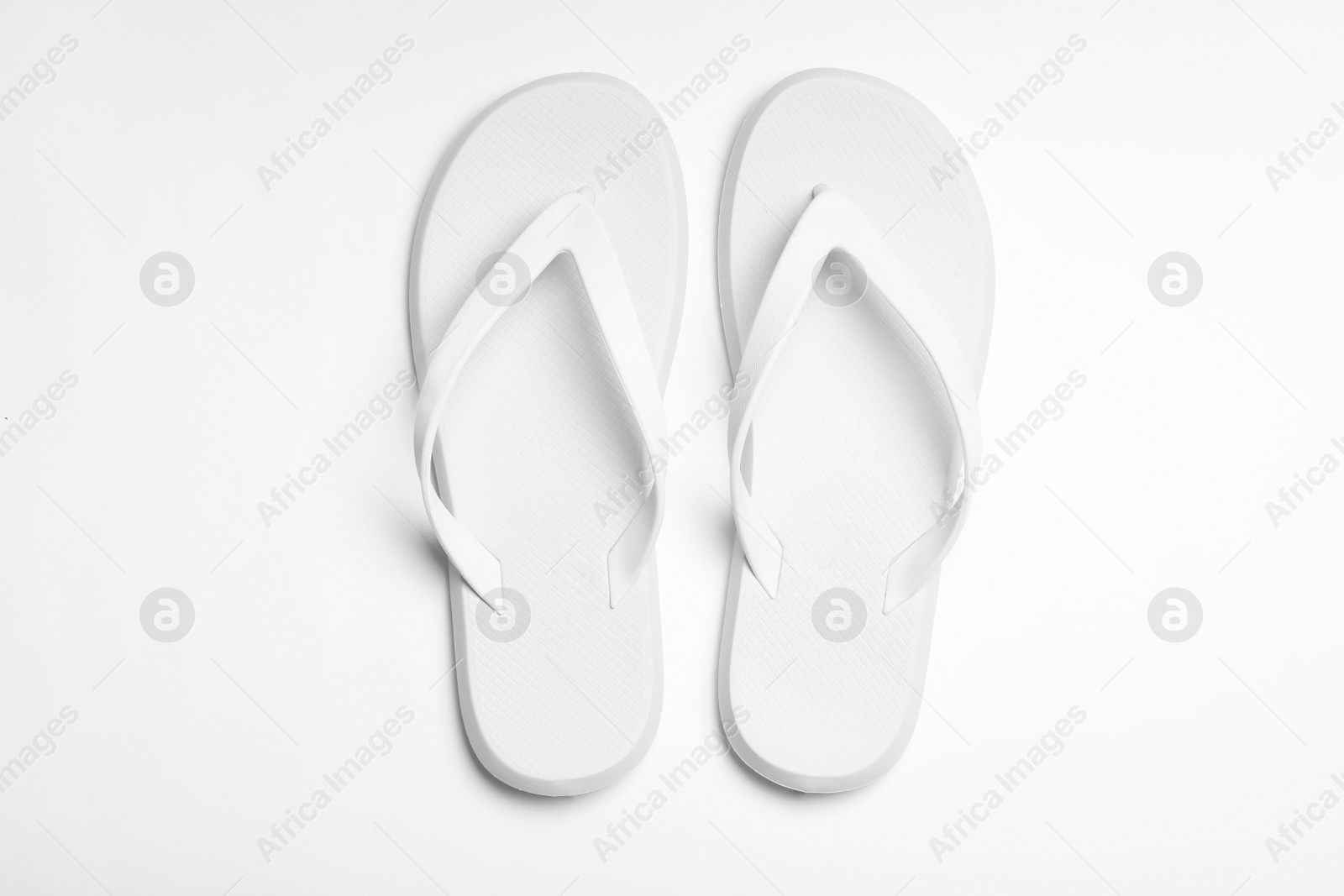 Photo of Pair of flip flops on white background, top view. Beach accessories