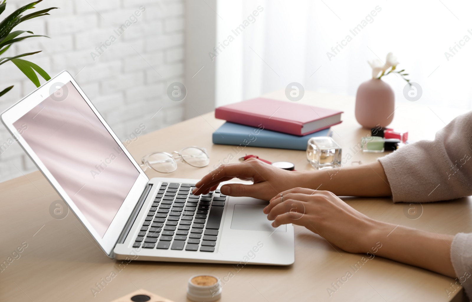 Photo of Blogger working with laptop at table, closeup