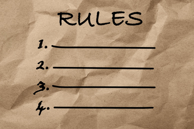 Image of Brown crumpled paper with list of rules as background, top view