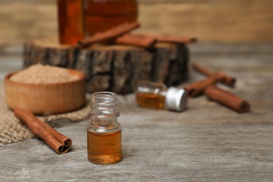 Photo of Closeup of bottle with cinnamon oil on wooden table