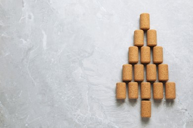 Photo of Christmas tree made of wine corks on light grey table, top view. Space for text