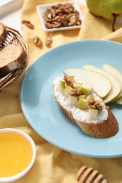 Photo of Delicious ricotta bruschetta with pear and walnut served on table, closeup