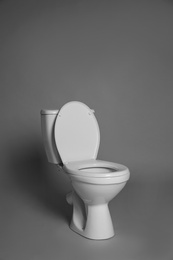 Photo of New ceramic toilet bowl on grey background