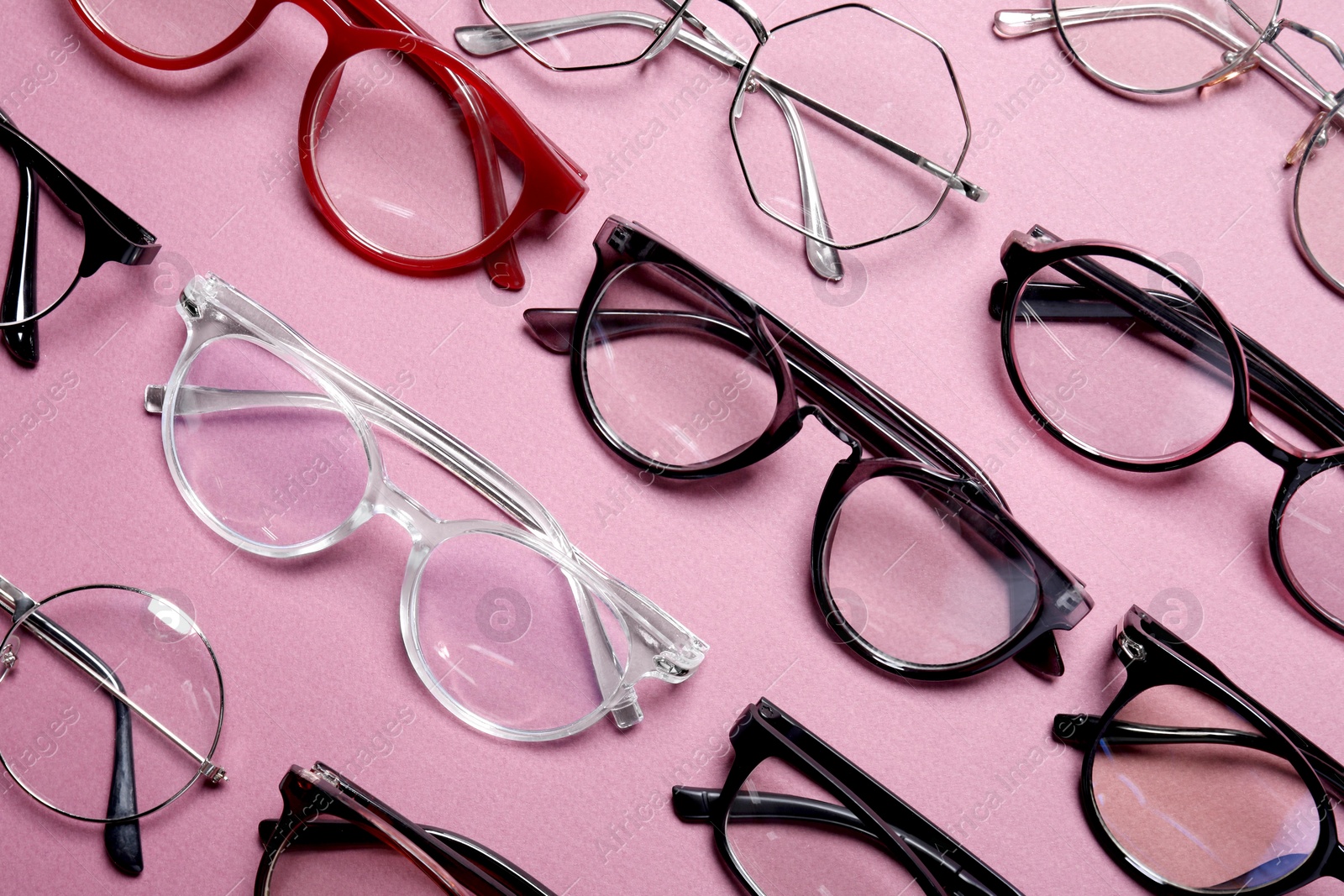 Photo of Different stylish glasses on pink background, flat lay