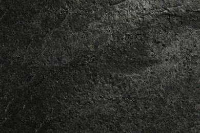 Photo of Texture of dark grey stone surface as background, closeup