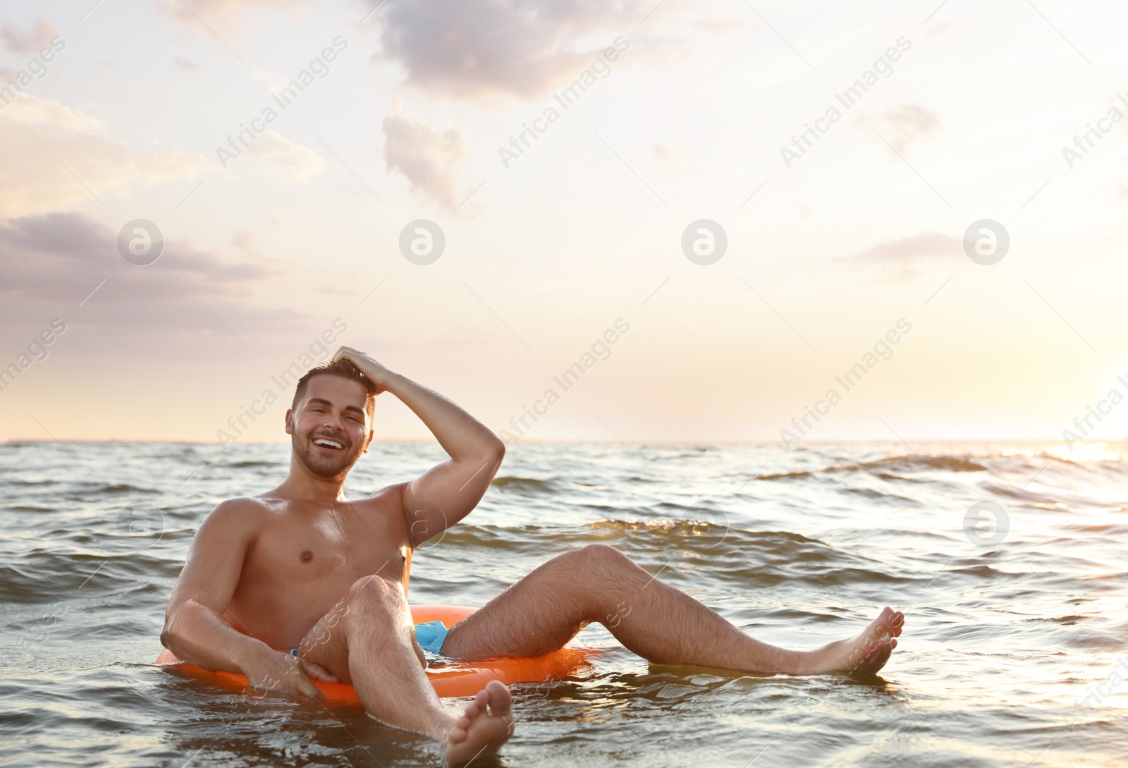 Photo of Happy young man on inflatable ring in water