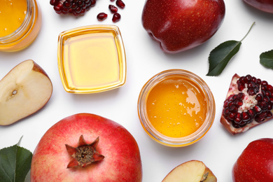 Honey, apples and pomegranates on white background, flat lay. Rosh Hashanah holiday