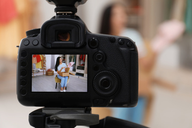 Fashion blogger recording new video in room, focus on camera