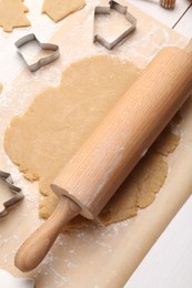 Photo of Making Christmas cookies. Raw dough, cutters and rolling pin on white table