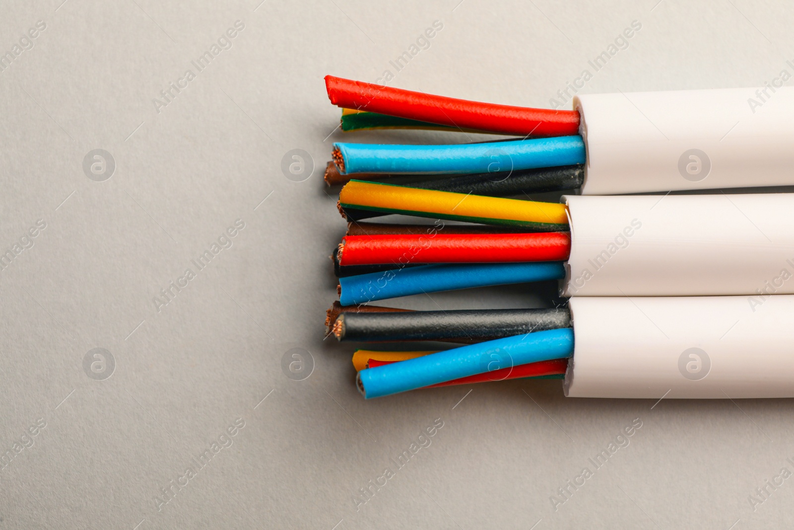 Photo of Electrical cables with wires on light background, closeup