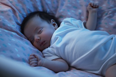Photo of Cute newborn baby sleeping in crib at night