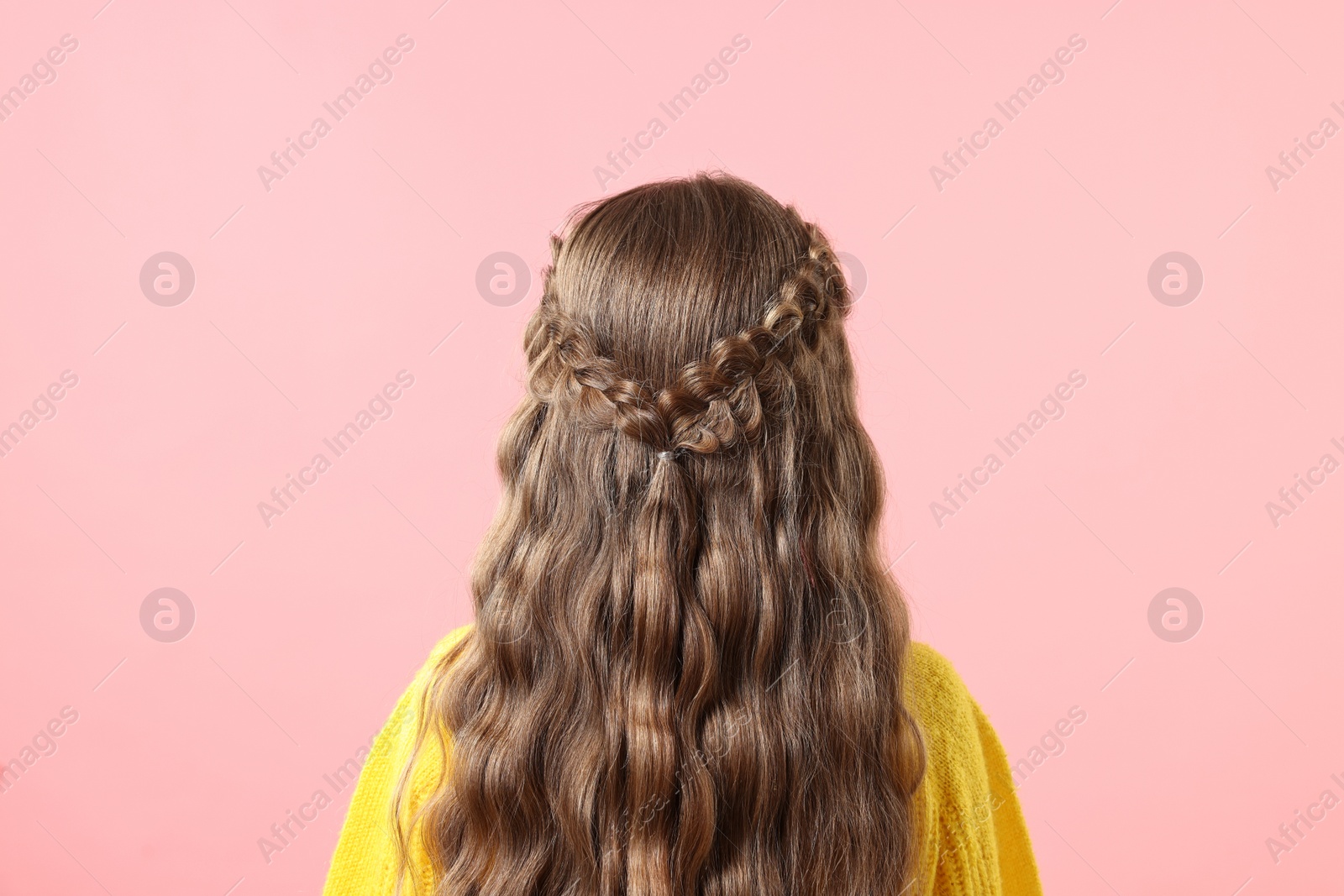 Photo of Little girl with braided hair on pink background, back view