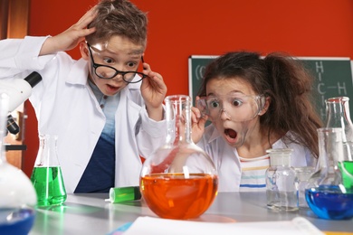 Children doing chemical research in laboratory. Dangerous experiment