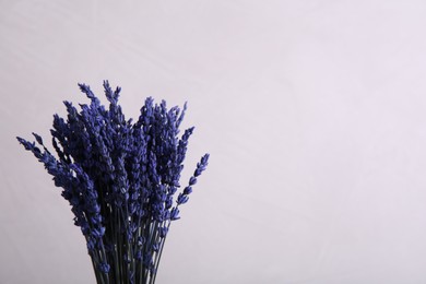 Photo of Bouquet of beautiful preserved lavender flowers on beige background, closeup. Space for text