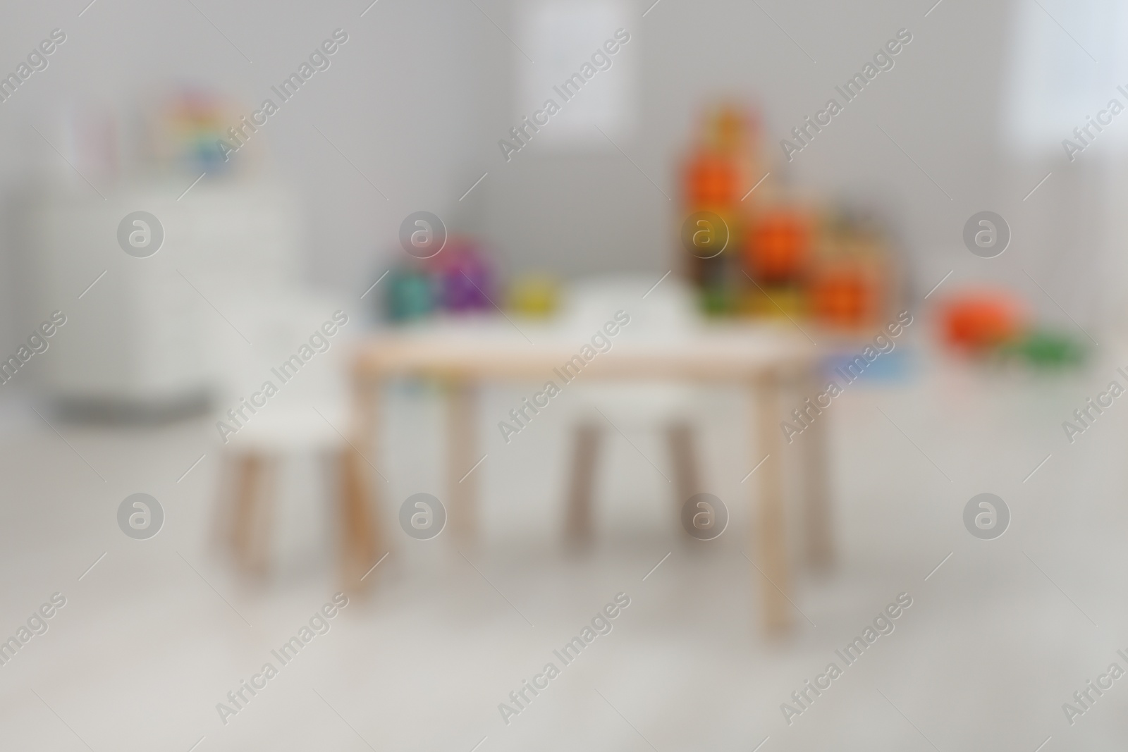 Photo of Spacious playroom with furniture and toys in kindergarten, blurred view