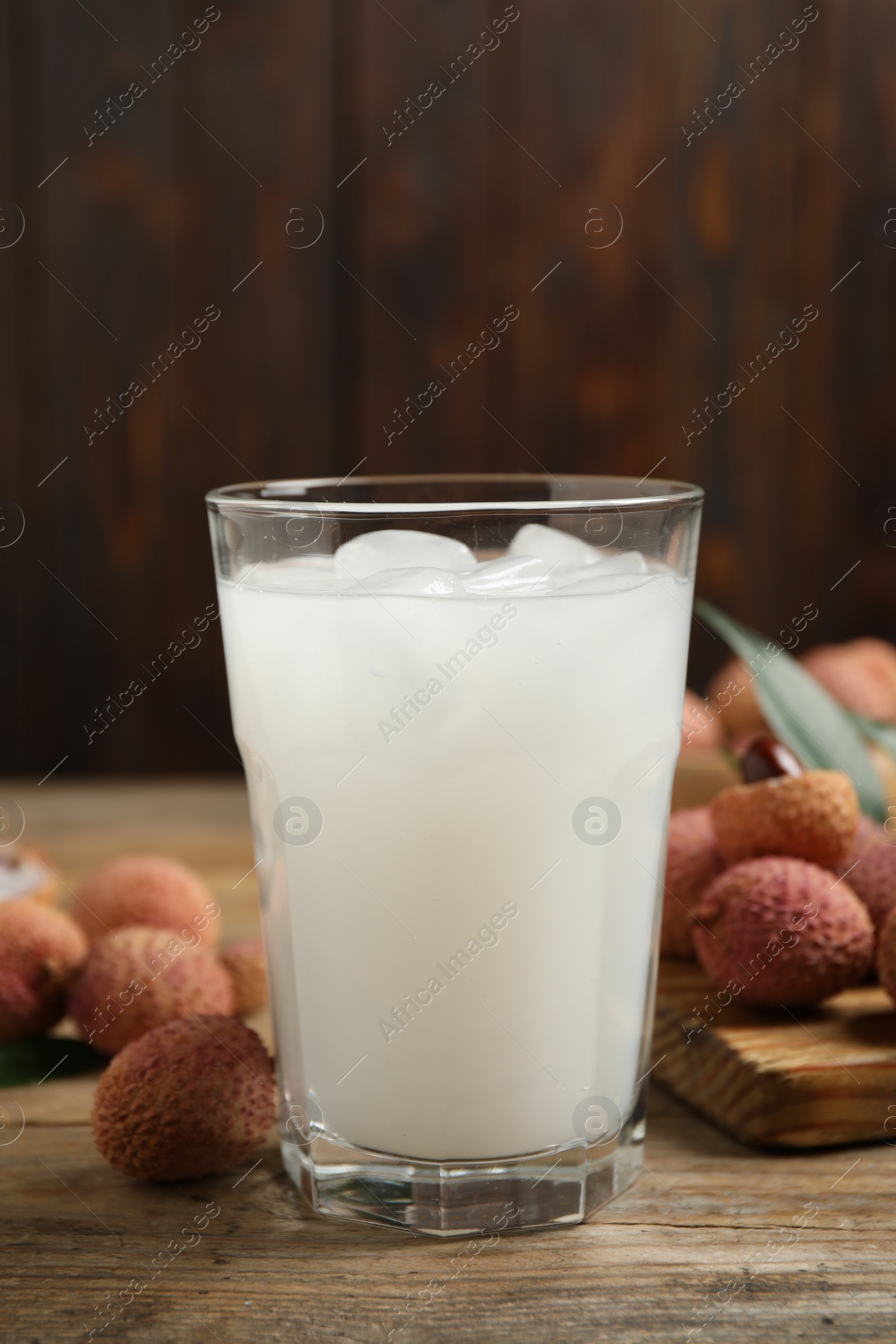 Photo of Fresh lychee juice on wooden table, closeup