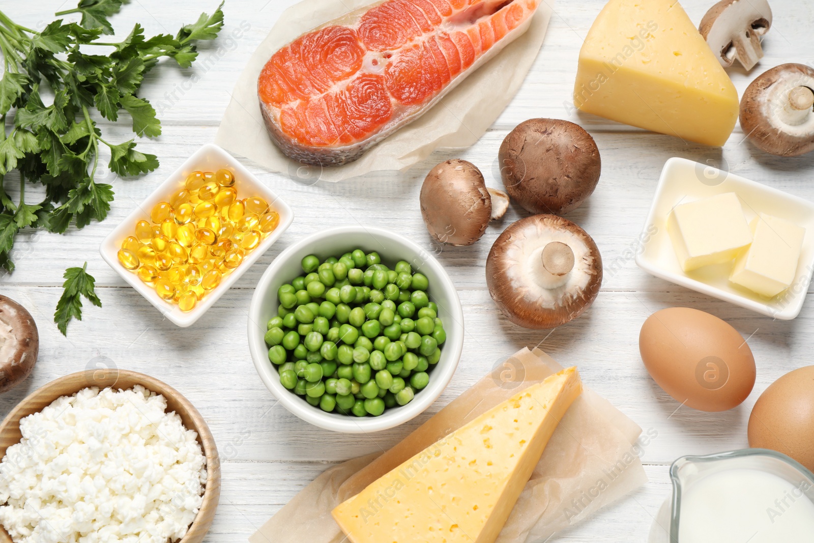 Photo of Flat lay composition with products rich in vitamin D on white wooden table