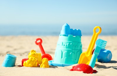 Photo of Different child plastic toys on sandy beach