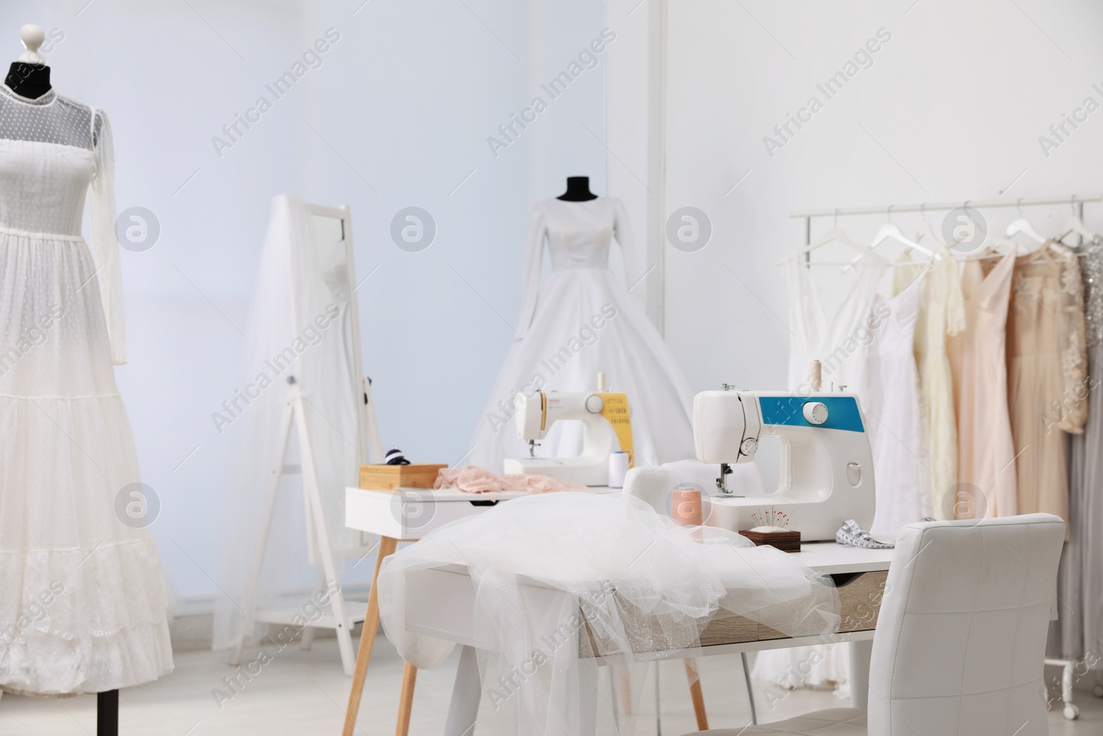 Photo of Dressmaking workshop interior with wedding dresses and equipment