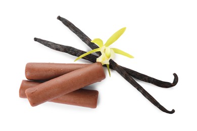 Photo of Glazed curd cheese bars, vanilla pods and flower isolated on white, top view