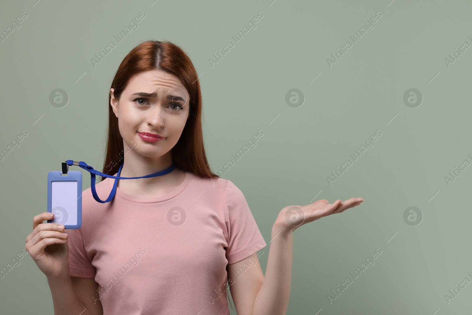 Photo of Disappointed woman with vip pass badge on pale green background. Space for text