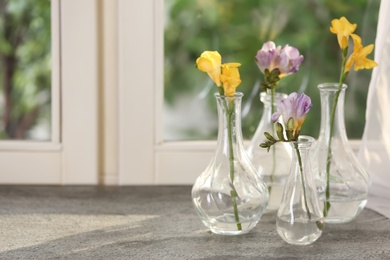 Photo of Beautiful fresh freesias on window sill indoors. Spring flowers