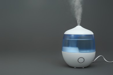 Modern air humidifier on grey background. Space for text