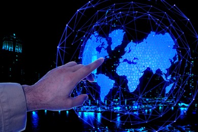 Image of Man pointing at digital model of Earth on dark background, closeup