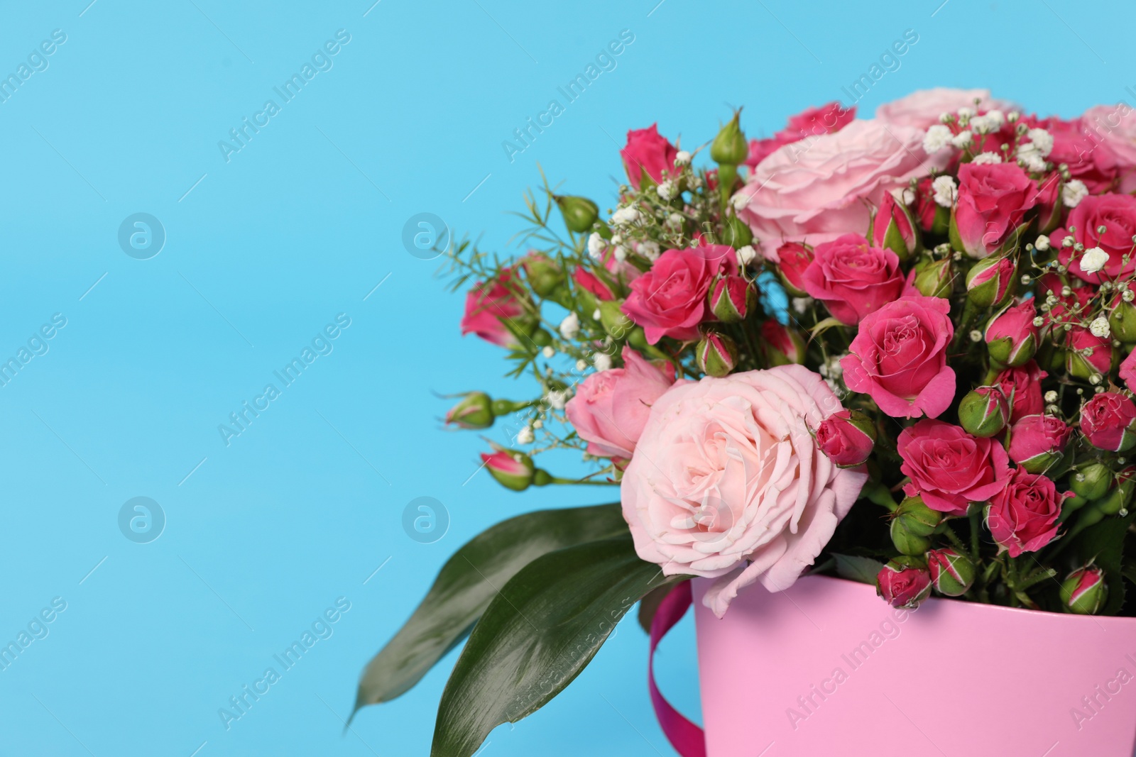 Photo of Beautiful bouquet of flowers in paper gift box on color background, closeup. Space for text