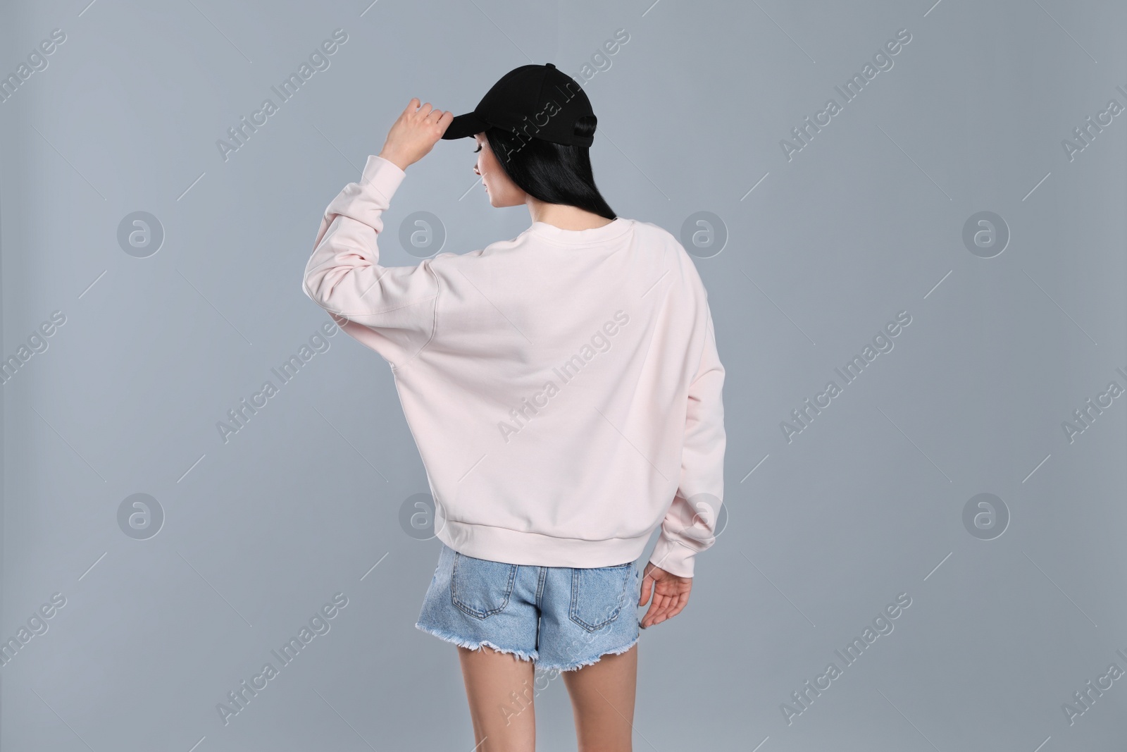 Photo of Young woman in sweater on grey background. Mock up for design