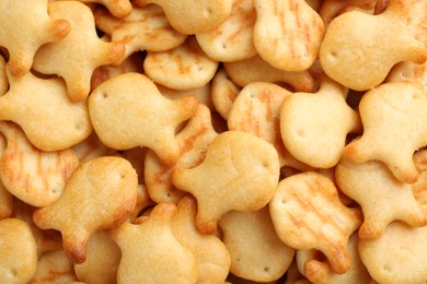 Photo of Delicious goldfish crackers as background, closeup view