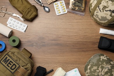 Photo of Frame of military first aid kit on wooden table, flat lay. Space for text