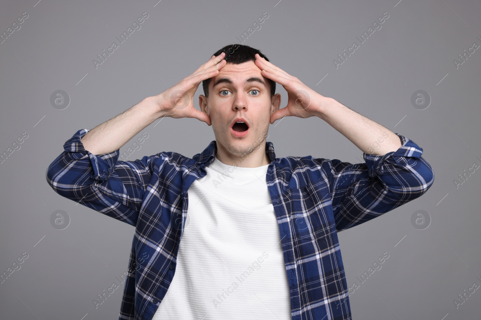 Photo of Portrait of surprised man on grey background