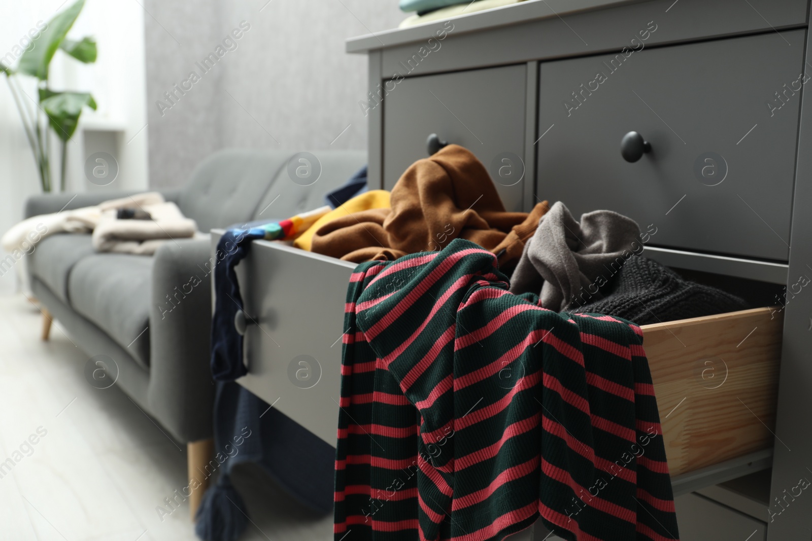 Photo of Cluttered room. Clothes in mess all around place